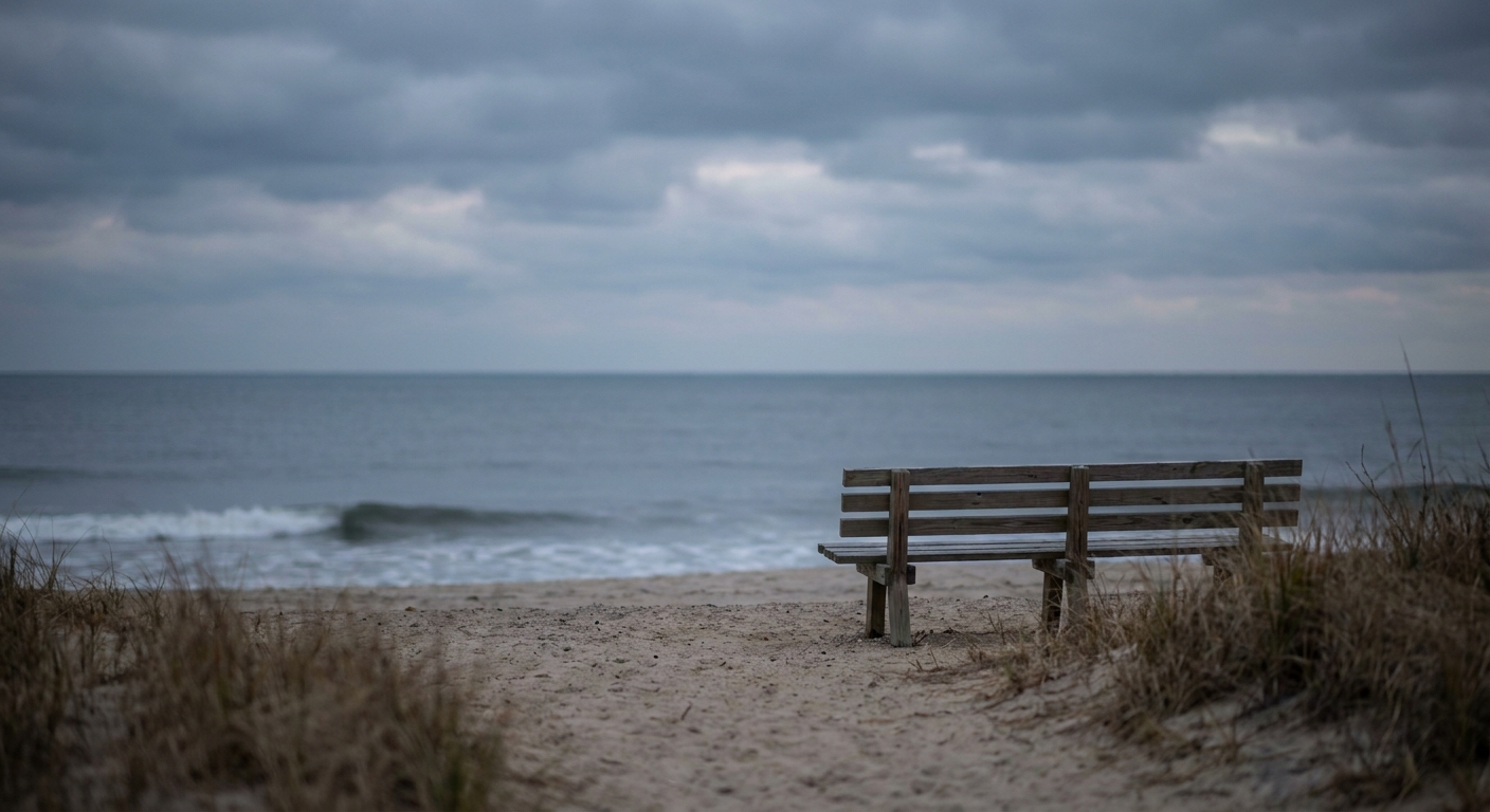 Empty bench facing the ocean at dusk on a New Jersey beach, symbolizing the solitude and reflection that often accompany living with serious mental illness